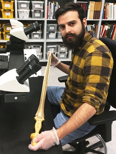 Valerio Gentile achter zijn microscoop om de zwaarden te onderzoeken.