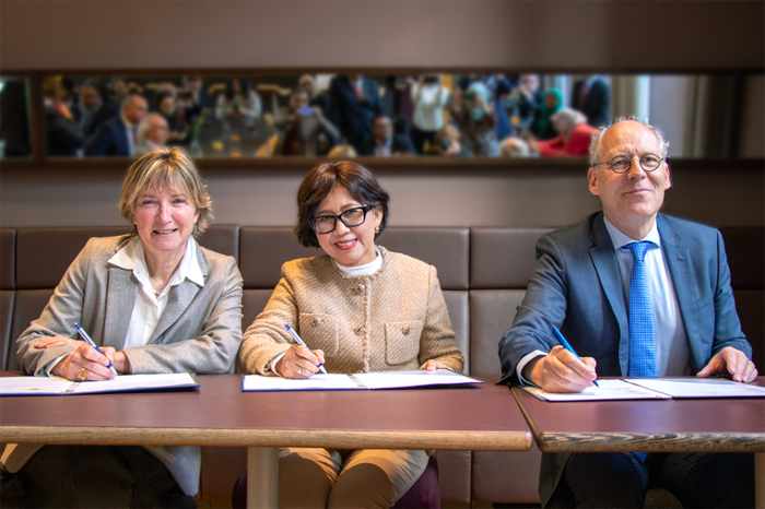 Voorzitter van het College van Bestuur Annetje Ottow (links), UGM-rector Ova Emilia (midden) en decaan Jasper Knoester (rechts) ondertekenen alledrie een exemplaar van de overeenkomst