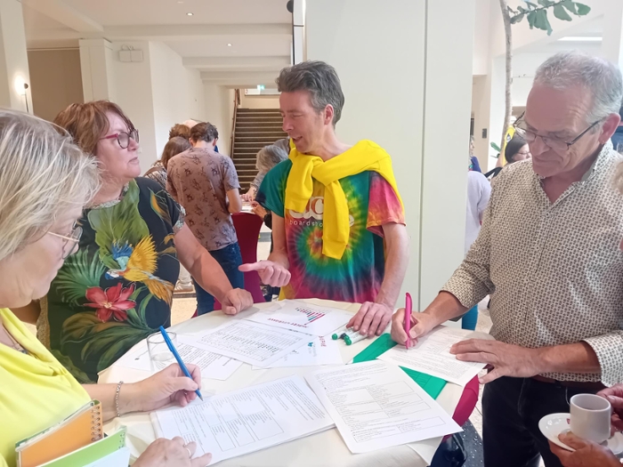 Inwoners staan rondom een stand over duurzaamheid