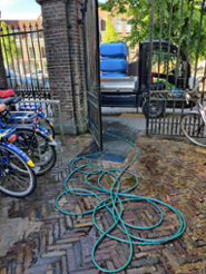 a hose with steaming water coming out of it lying on the streets in front of the Oude UB
