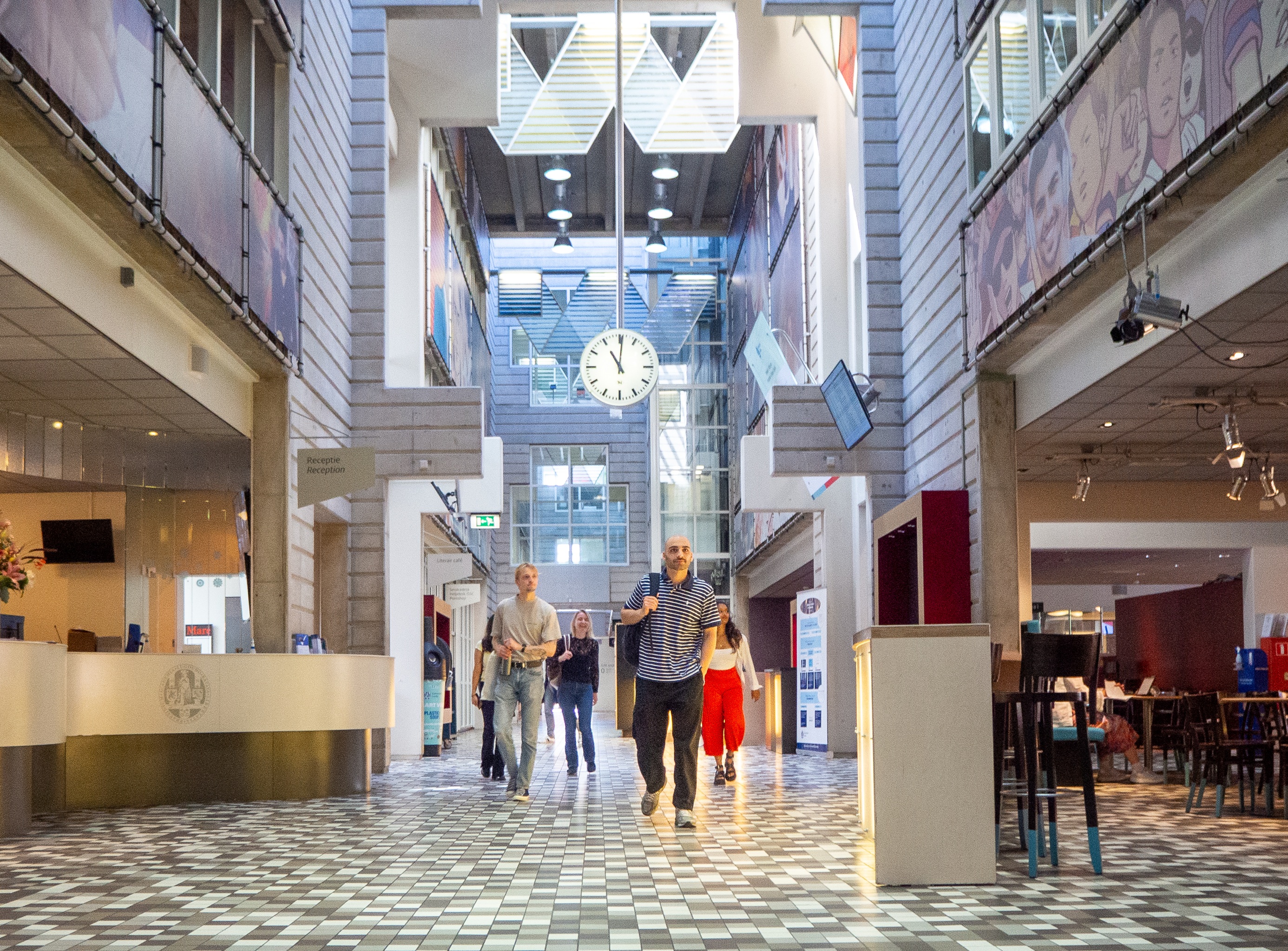 Students converse inside the main hall of the Lipsius Building