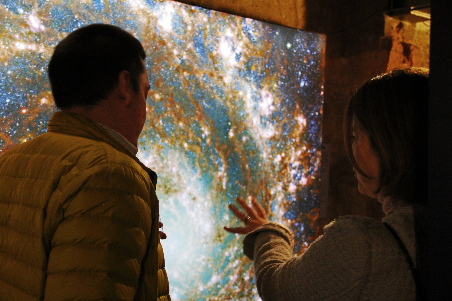 Two people looking at an image of a galaxy