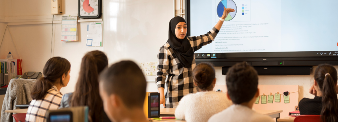 Vrouwelijke docent met hoofddoek geeft les op een islamitische school in Leiden
