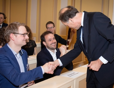 Rector magnificus Carel Stolker schudt de hand van de jonge Leidse onderzoekers Tom Louwerse (YAL) en Quentin Bourgeois (Jonge Akademie).