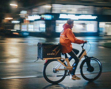 Een bezorger op de fiets die een maaltijd wegbrengt.