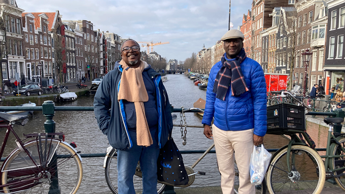 Twee Nigeriaanse geleerden poseren voor een foto op een brug in Amsterdam