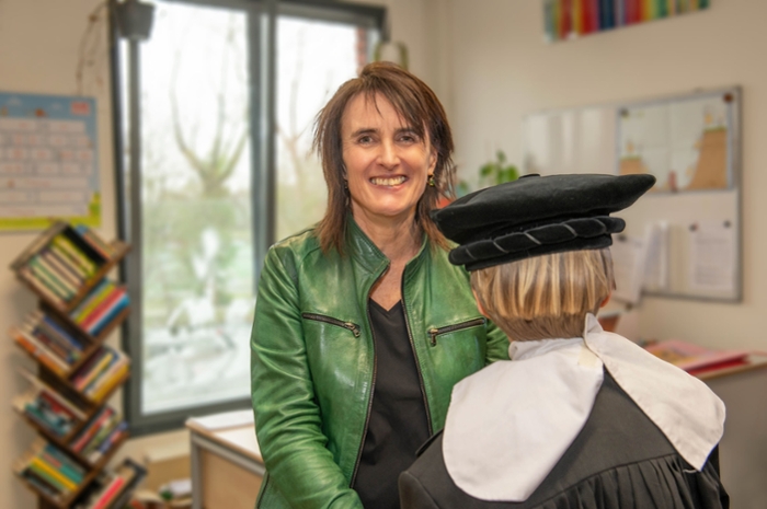 Miranda Boone laat een jongen met blond haar haar toga passen.