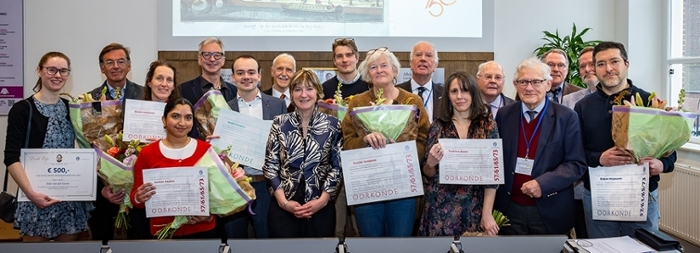 A group of people holding certificates and a bunch of flowers