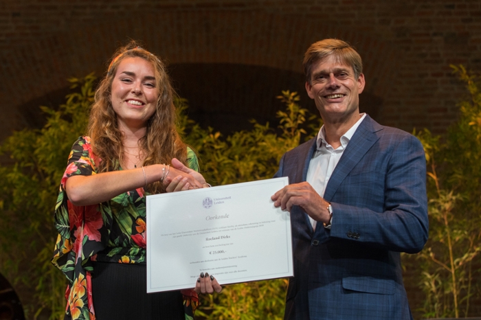 Roeland Dirks ontvangt de Onderwijsprijs van Ghislaine Voogd, voorzitter van het Leids Universitair Studentenplatform.