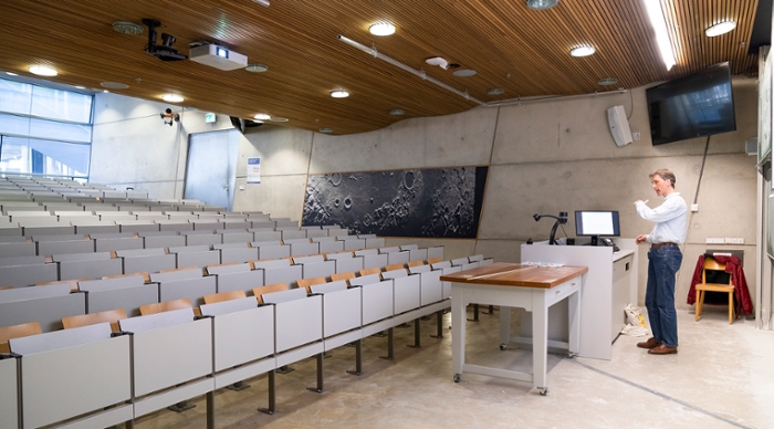 Photo of a lecturer recording his lecture in an empty lecture hall.