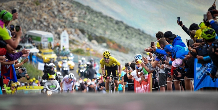 Primoz Roglic, kopman van Jumbo-Visma, fietst in de gele trui een berg op tussen het publiek, tijdens de Tour van 2020
