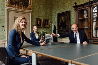 Njord-praeses Rosalie ten Wolde overhandigt het eerste exemplaar van 'Njord in de Oorlogstijd' aan rector magnificus Carel Stolker. In het midden ab actis Julia van Sluijs.