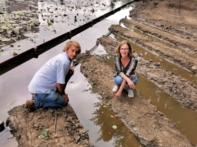 Researchers Maarten Schrama and Martina Vijver squat by the first new ditches at the Living Lab’s new location in the middle of the Leiden Bio Science Park.