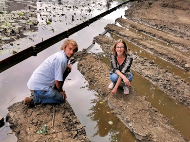 Onderzoekers Maarten Schrama en Martina Vijver gehurkt bij de eerste nieuwe slootjes van het Levend Lab op de nieuwe locatie in het hart van het Leiden Bio Science Park