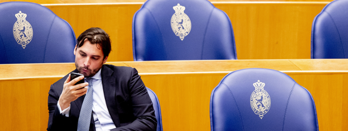 Thierry Baudet looks on his phone in the parliament hall.