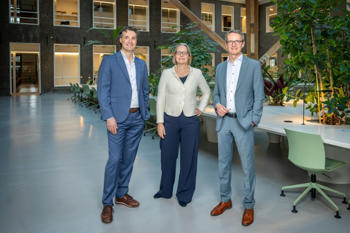 Drie mensen poseren voor de foto.