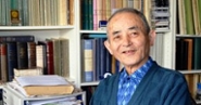 Professor Takamitsu Muraoka zit vóór een boekenkast