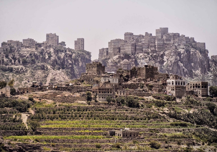 A photo of a landscape in Yemen with farmland and buildings.
