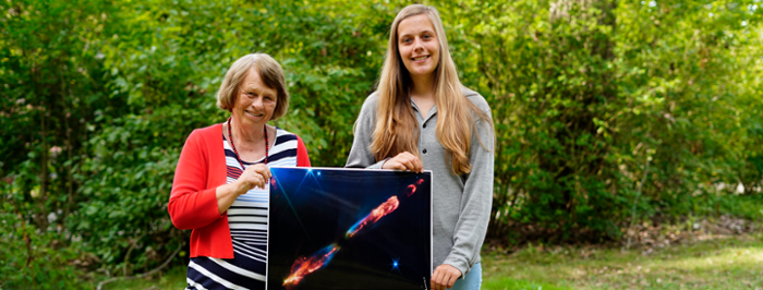 Merel Reitsma together with her professor Ewine van Dishoeck and the James Webb Space Telescope image of star HH211.