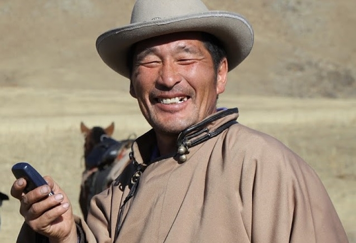 Een advertentie voor Mobicom (Mongolia Telecom) met een herder en zijn mobiele telefoon (foto door Richard Fraser).