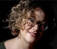 Een vrouw krullend haar en een bril