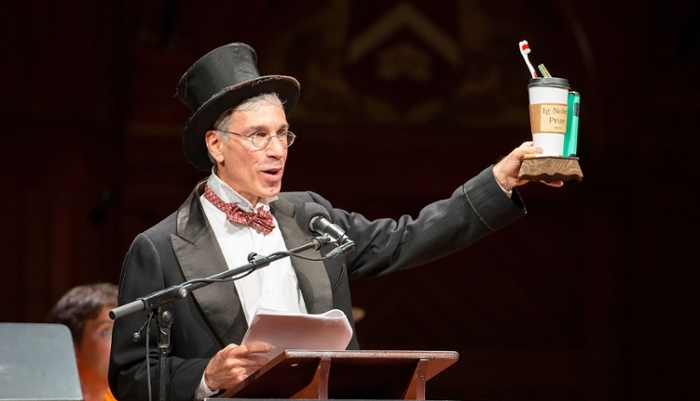 Marc Abrahams, met hoge hoed, op houdt een Ig Nobelprijs vast: een koffiebeker met daarin een tandenborstel.