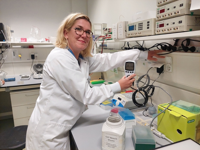 Een laboratoriummedewerker houdt een schakelklok in haar hand